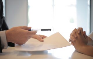 Man handing women a pen